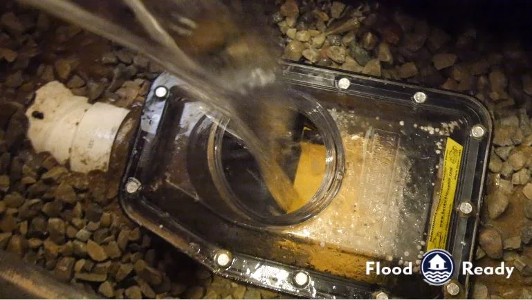 Backwater valve being flushed during maintenance