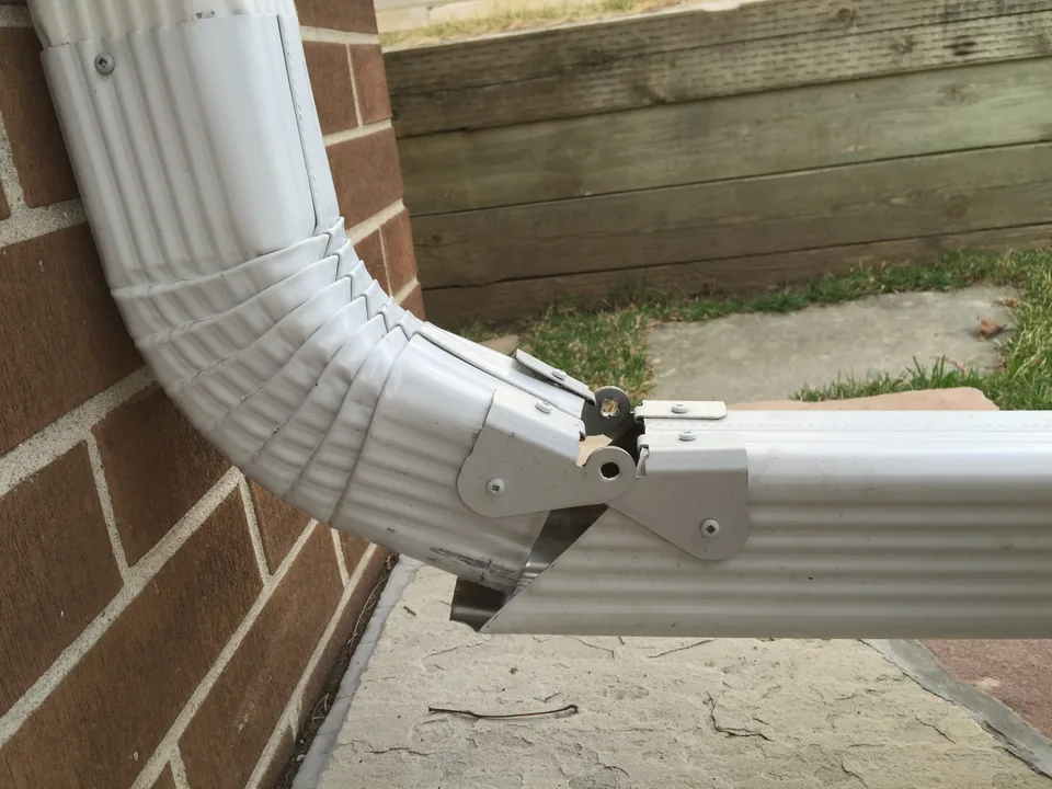 Hinged downspout extension detail for access and maintenance